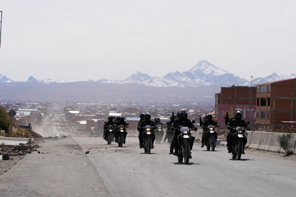 Police patrol a highway in El Alto, Bolivia, after the president declared a state of emergency to remove road blockades.