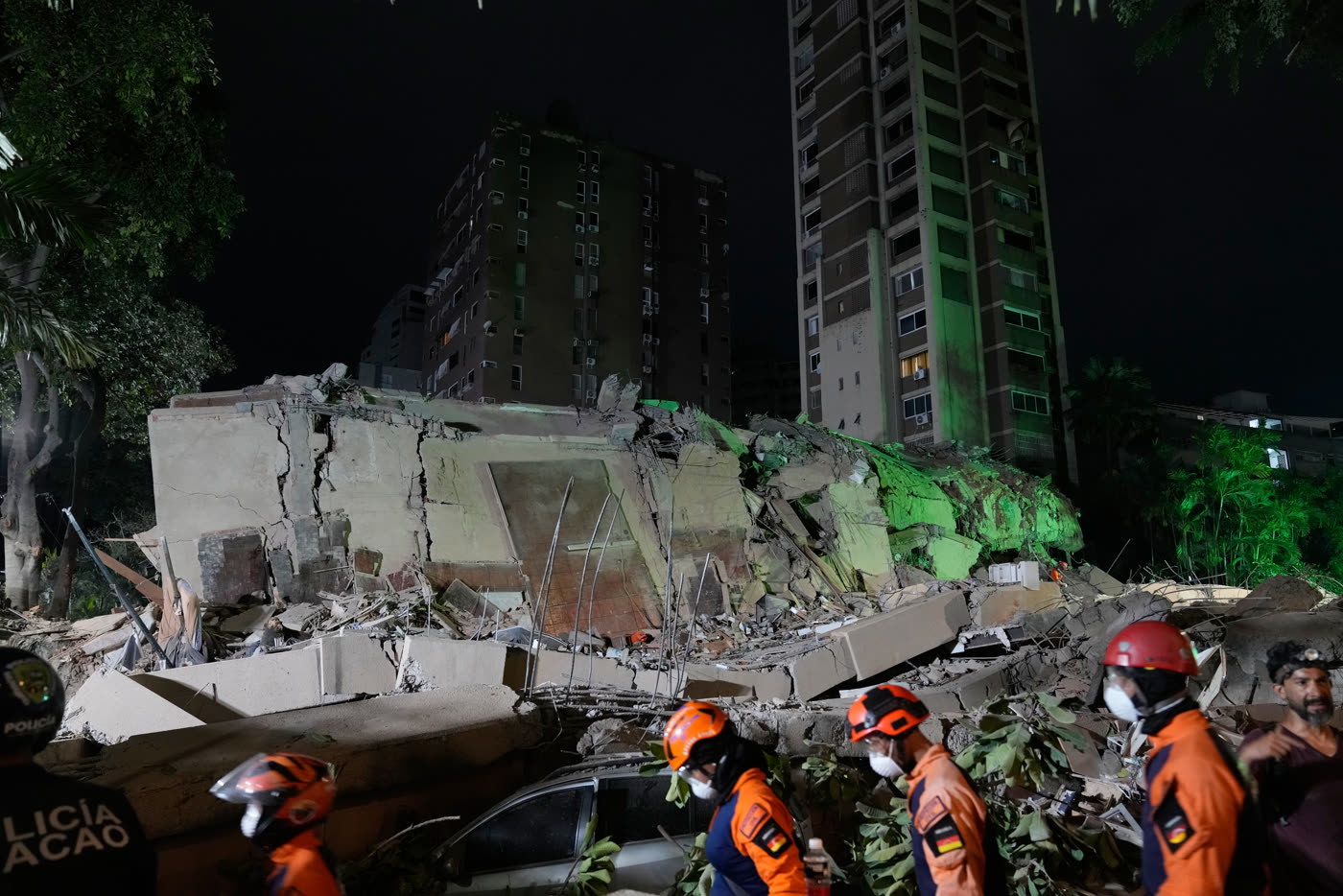 2026 年 6 月委内瑞拉加拉加斯地震后，夜间急救人员经过一栋倒塌建筑。