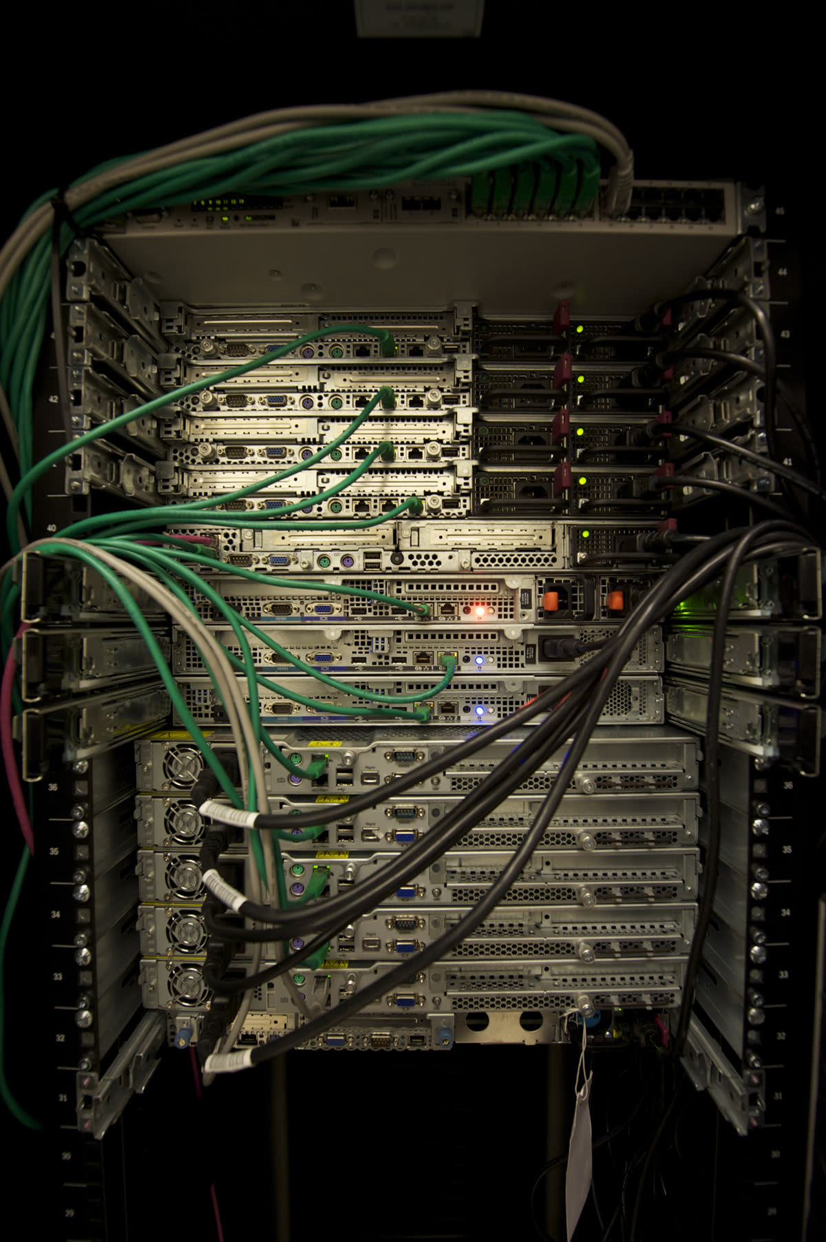 A close photograph of servers, network cables, and power supplies inside a rack.