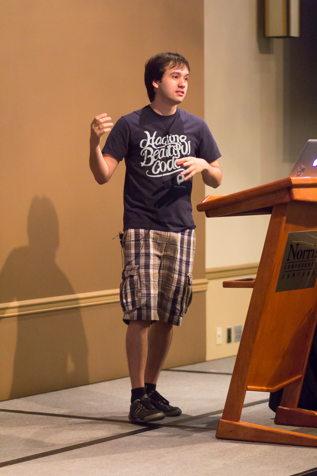 José Valim speaking into a microphone at ElixirConf in 2014.