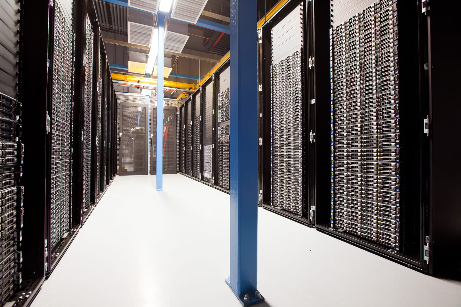 A real photograph of server racks and cabling in a data center aisle.