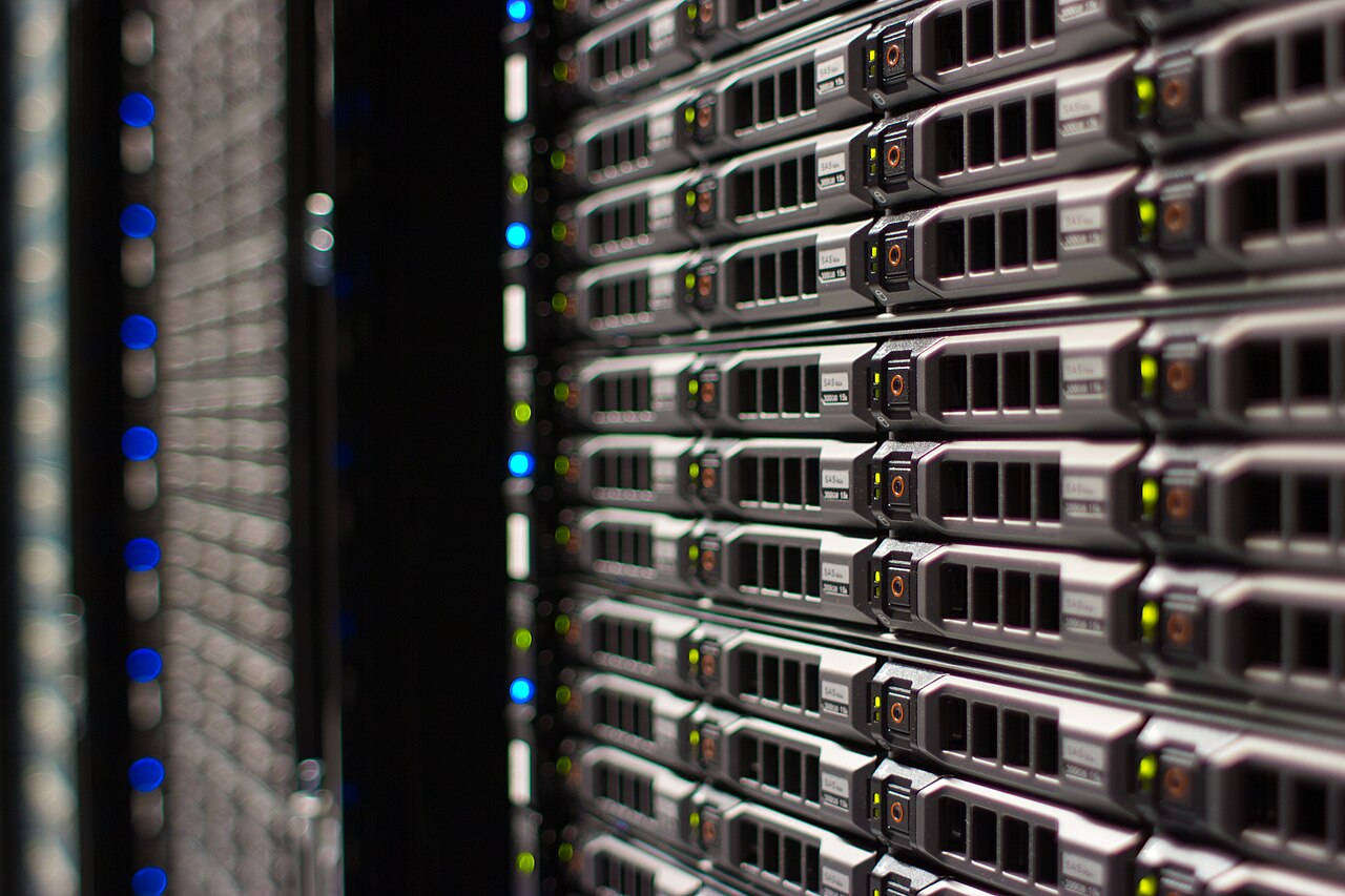 Close-up photograph of Wikimedia Foundation servers stacked in a rack with status lights visible.