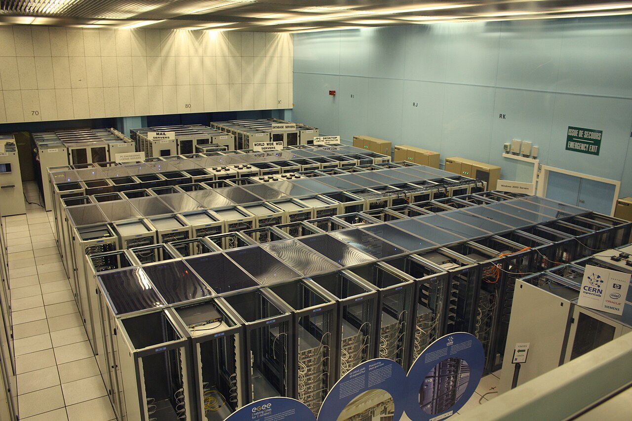 CERN 数据中心里成排的服务器机柜，照片从通道拍摄，机柜后侧线缆外露。