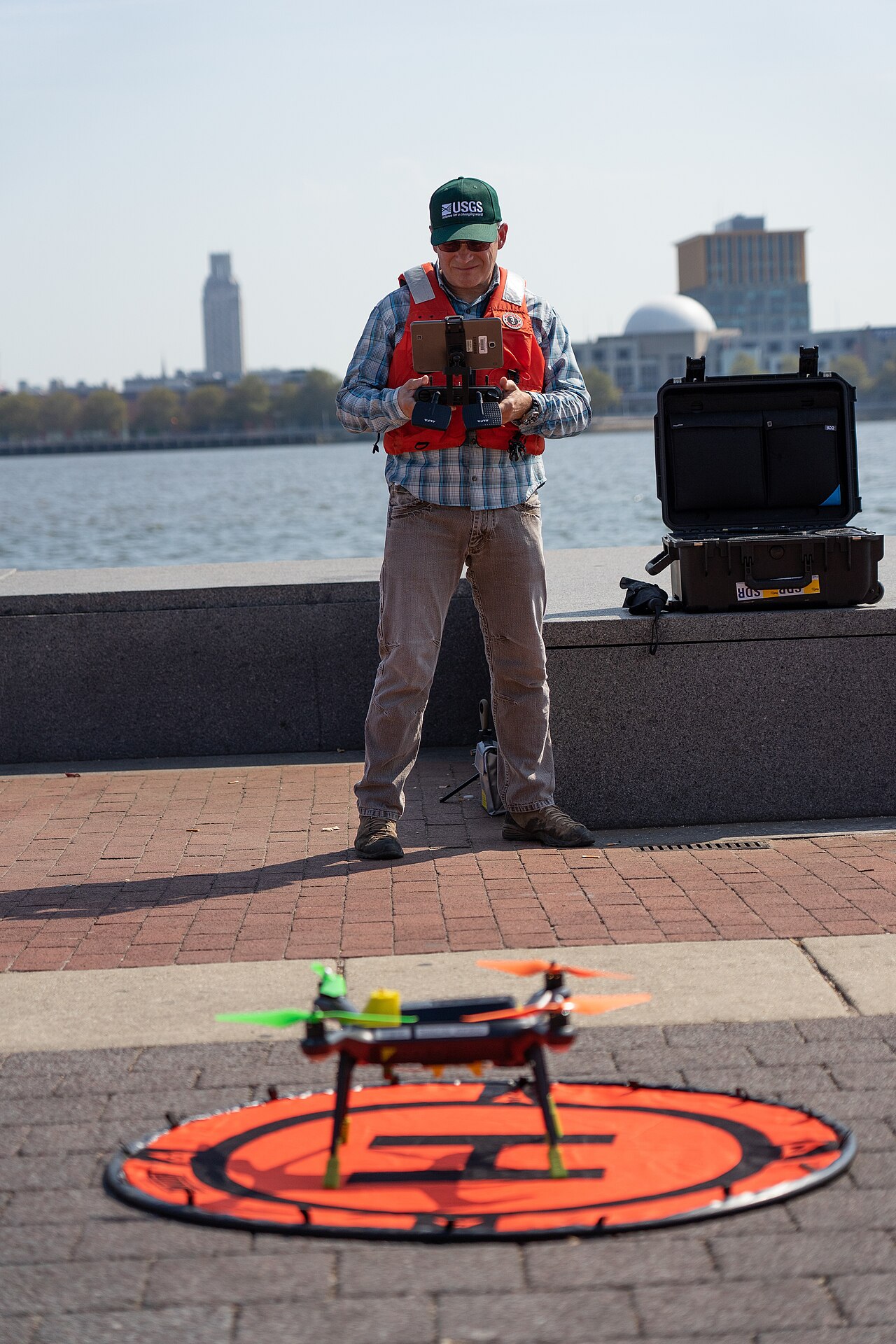 A USGS employee prepares an unmanned aerial vehicle for takeoff in a field setting.