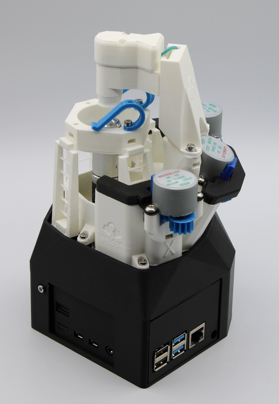 A real OpenFlexure Microscope standing on a white surface, showing its printed body, sample stage, optics module, and electronics housing.