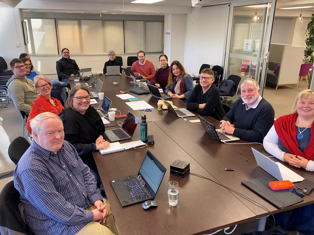 Participants at an OpenRefine workshop in Wellington, New Zealand, sitting around tables with laptops.