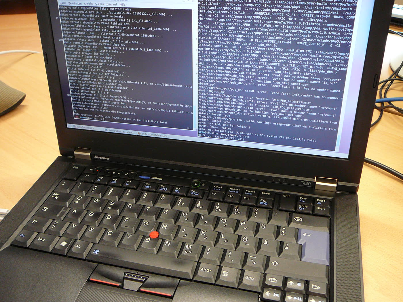Photograph of a Lenovo ThinkPad laptop running Ubuntu Linux with terminal output on the screen.