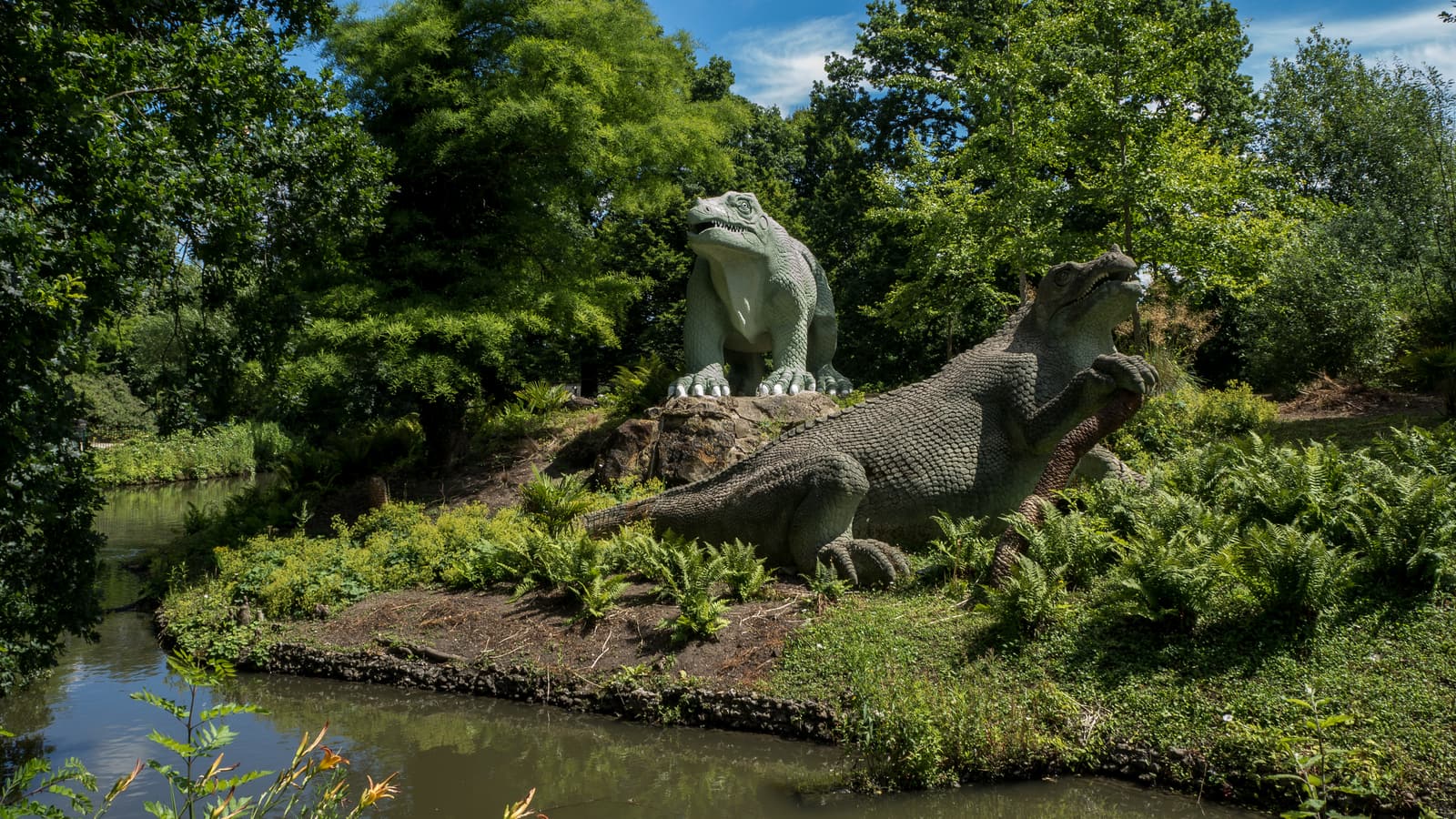 Photograph of the two Crystal Palace Iguanodon sculptures on their island in Crystal Palace Park, London.