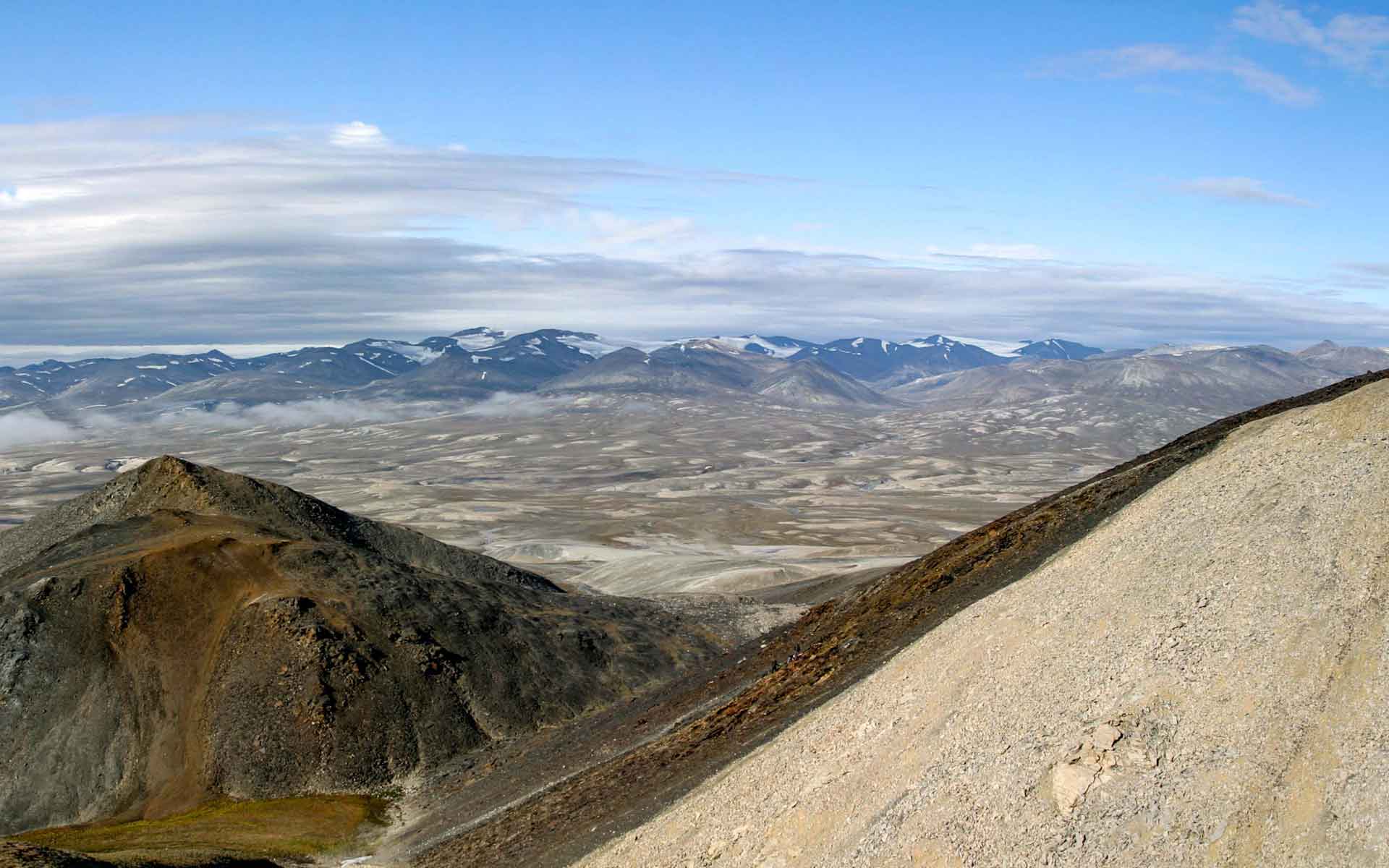 Panoramic field photograph of the Sirius Passet main section in Peary Land, North Greenland, with pale carbonate rocks faulted against darker Cambrian strata under a wide Arctic sky.