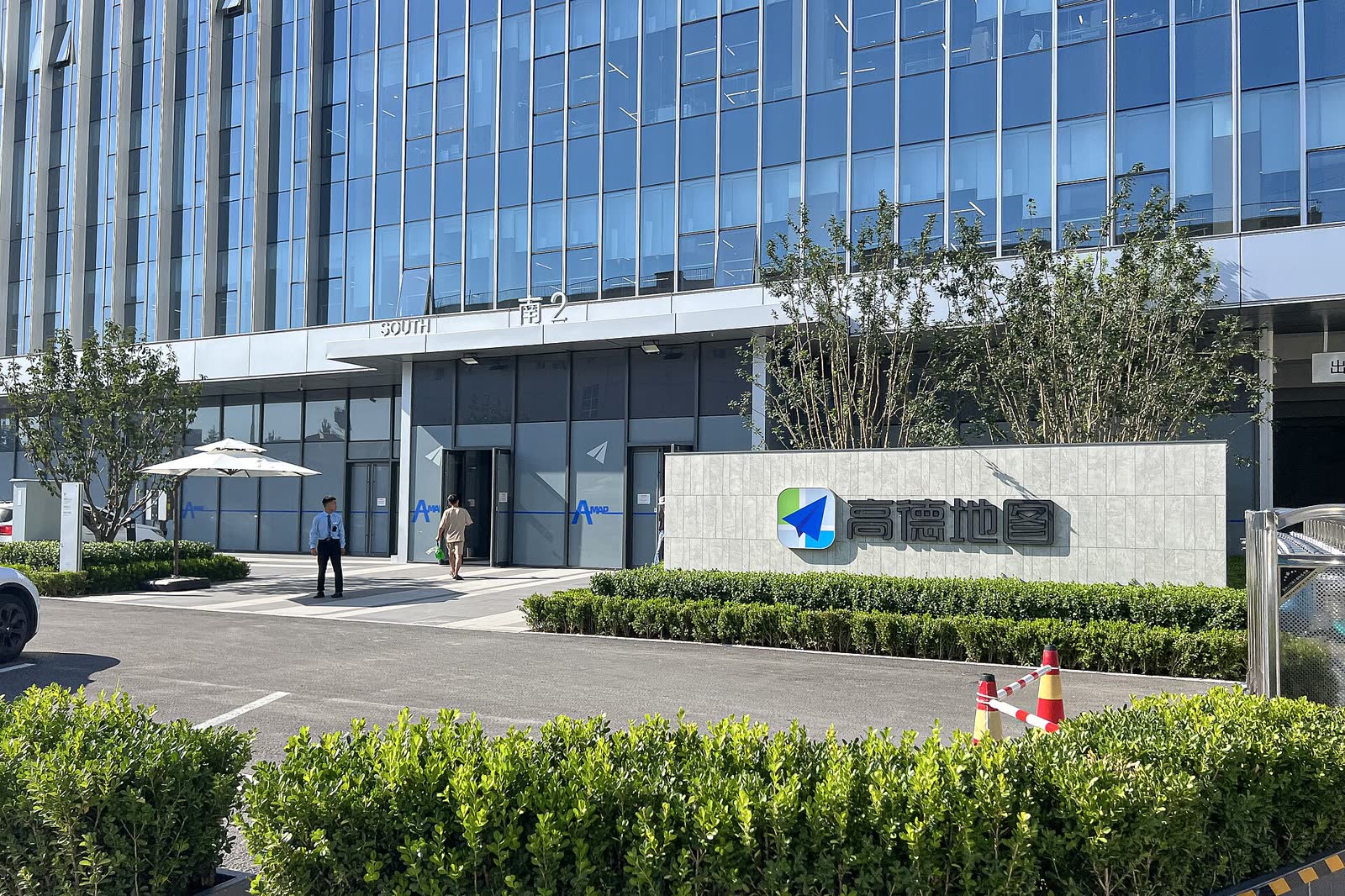 北京高德总部南门，玻璃办公楼门旁装有蓝绿相间的高德标志。