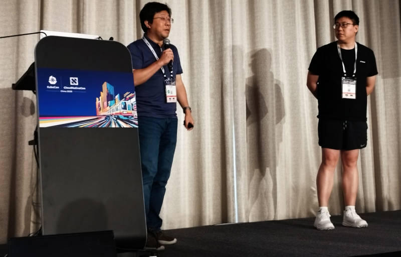 AIBrix presenters Liguang Xie and Jiaxin Shan speaking onstage at KubeCon + CloudNativeCon China 2025.