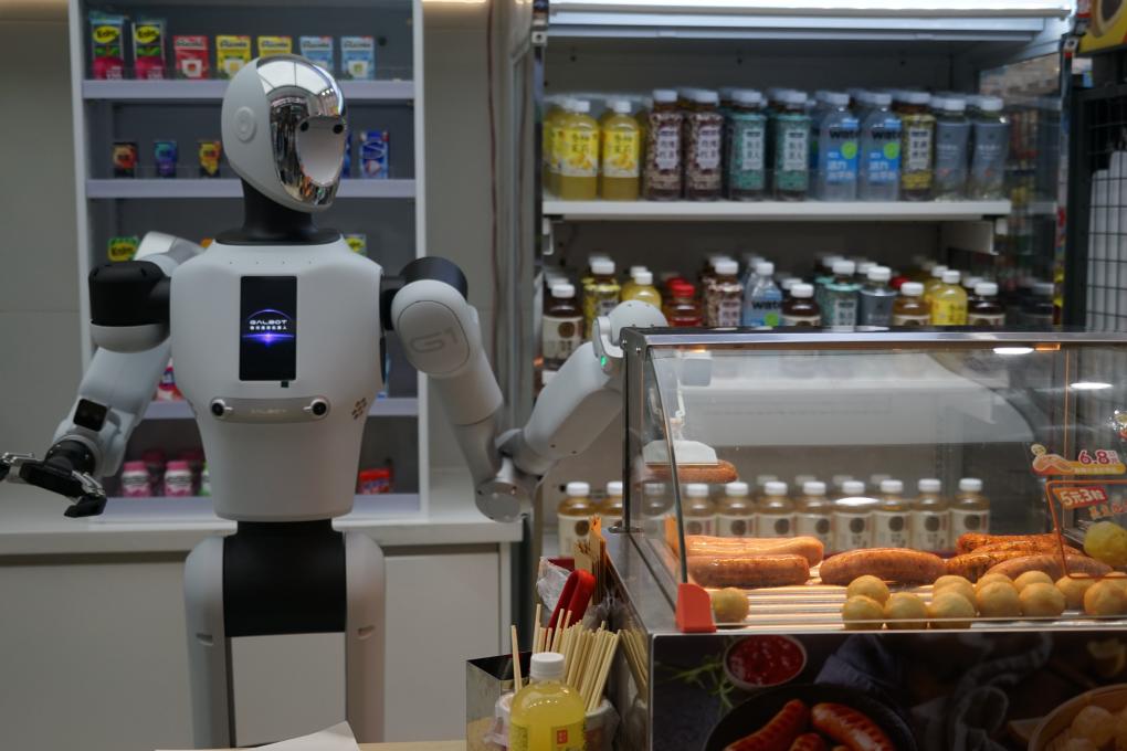 A Galbot G1 robot uses a gripper to pick up a grilled sausage inside a FamilyMart convenience store in Beijing.