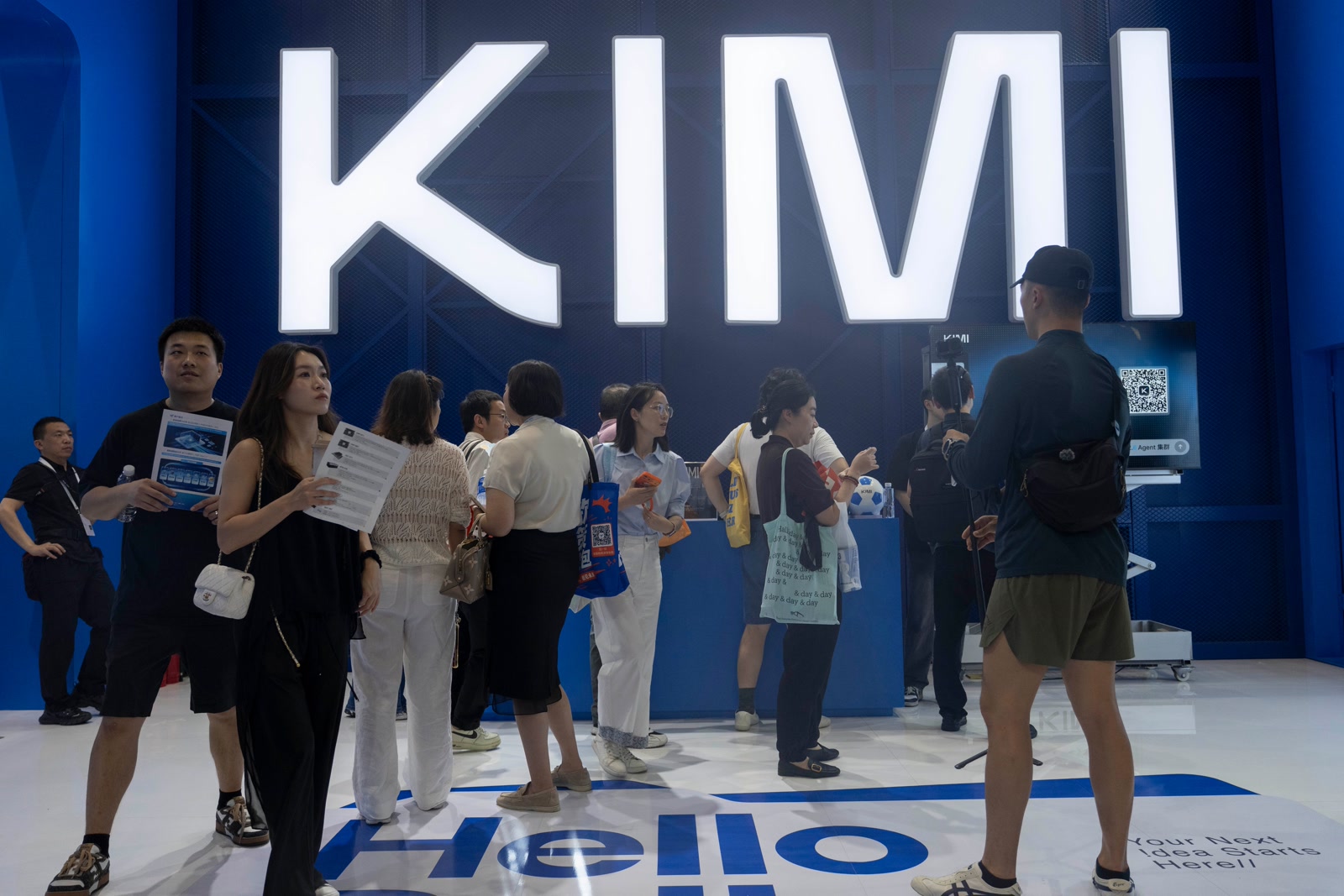 参观者聚集在上海世界人工智能大会上灯光映照的月之暗面 Kimi K3 展台周围。
