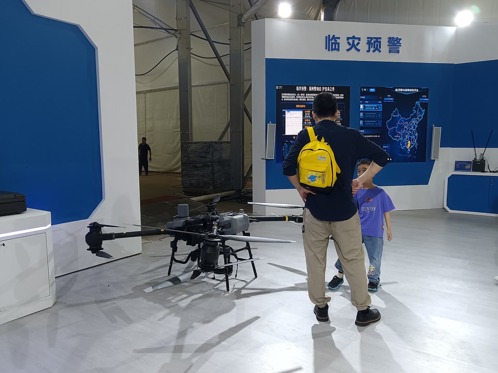 2025 年长沙工程机械展上，一架中国移动无人机陈列在灾害预警屏幕下方。