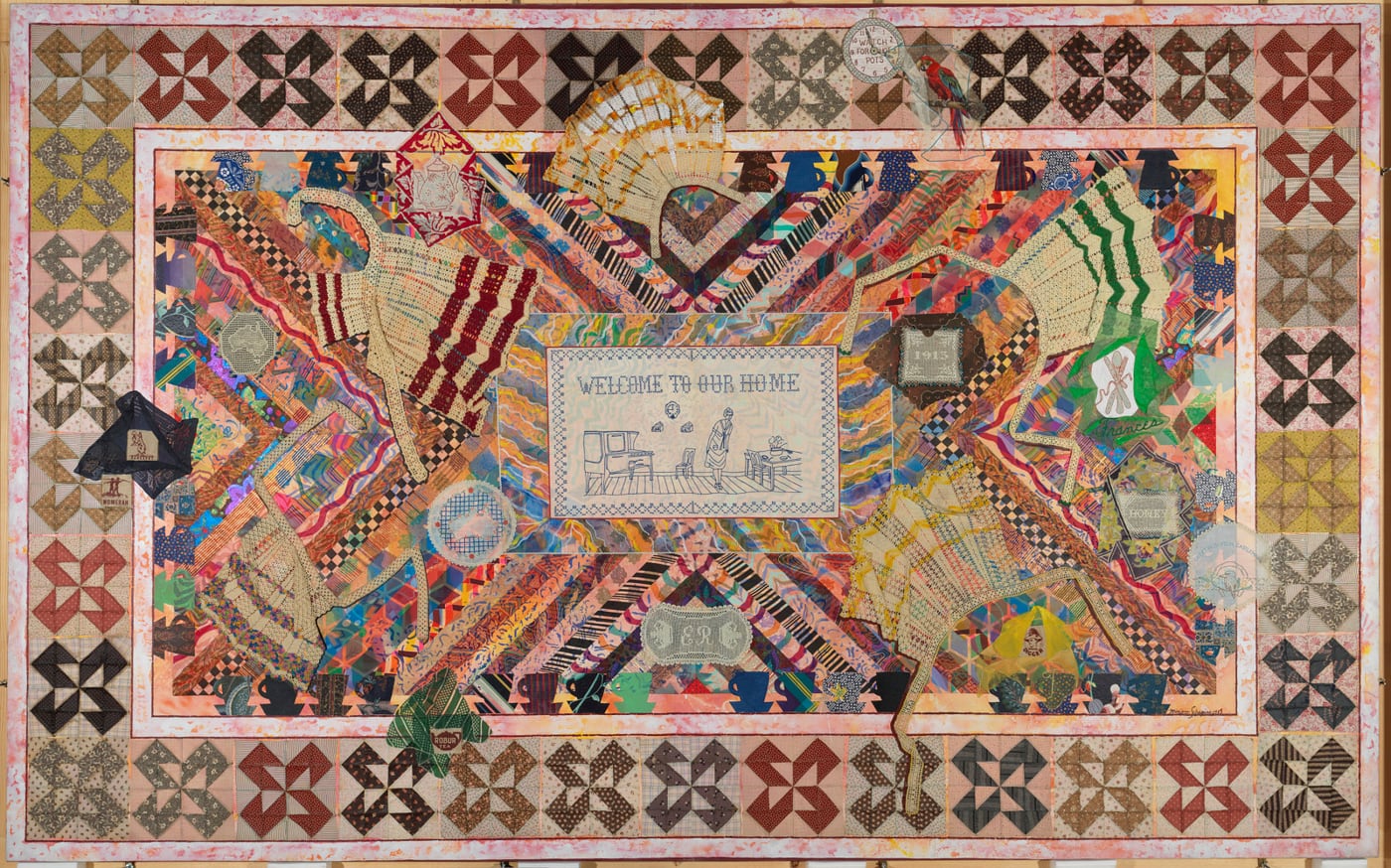 Miriam Schapiro's Wonderland, a large colorful femmage with quilt-block borders, collaged fabric, aprons, teacups, fans, and an embroidered domestic scene at the center.
