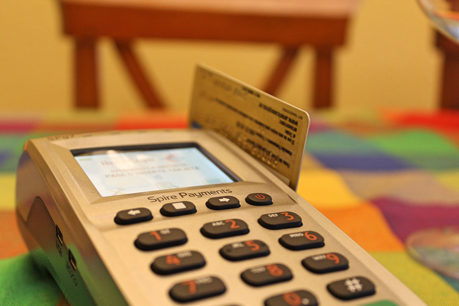 A payment card inserted into a countertop card terminal.