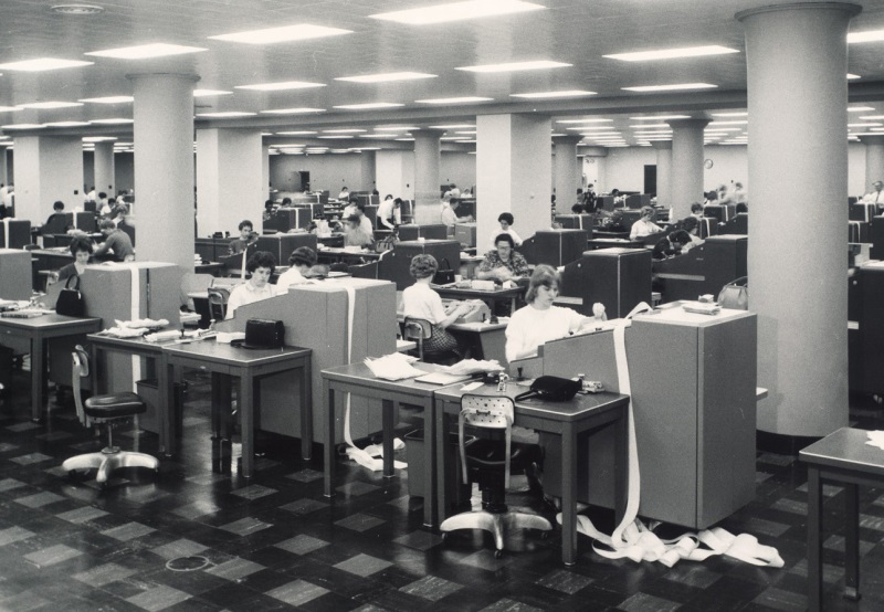 1964 年，圣路易斯联邦储备银行票据分拣室内，女职员操作 IBM 支票处理设备的黑白档案照片。
