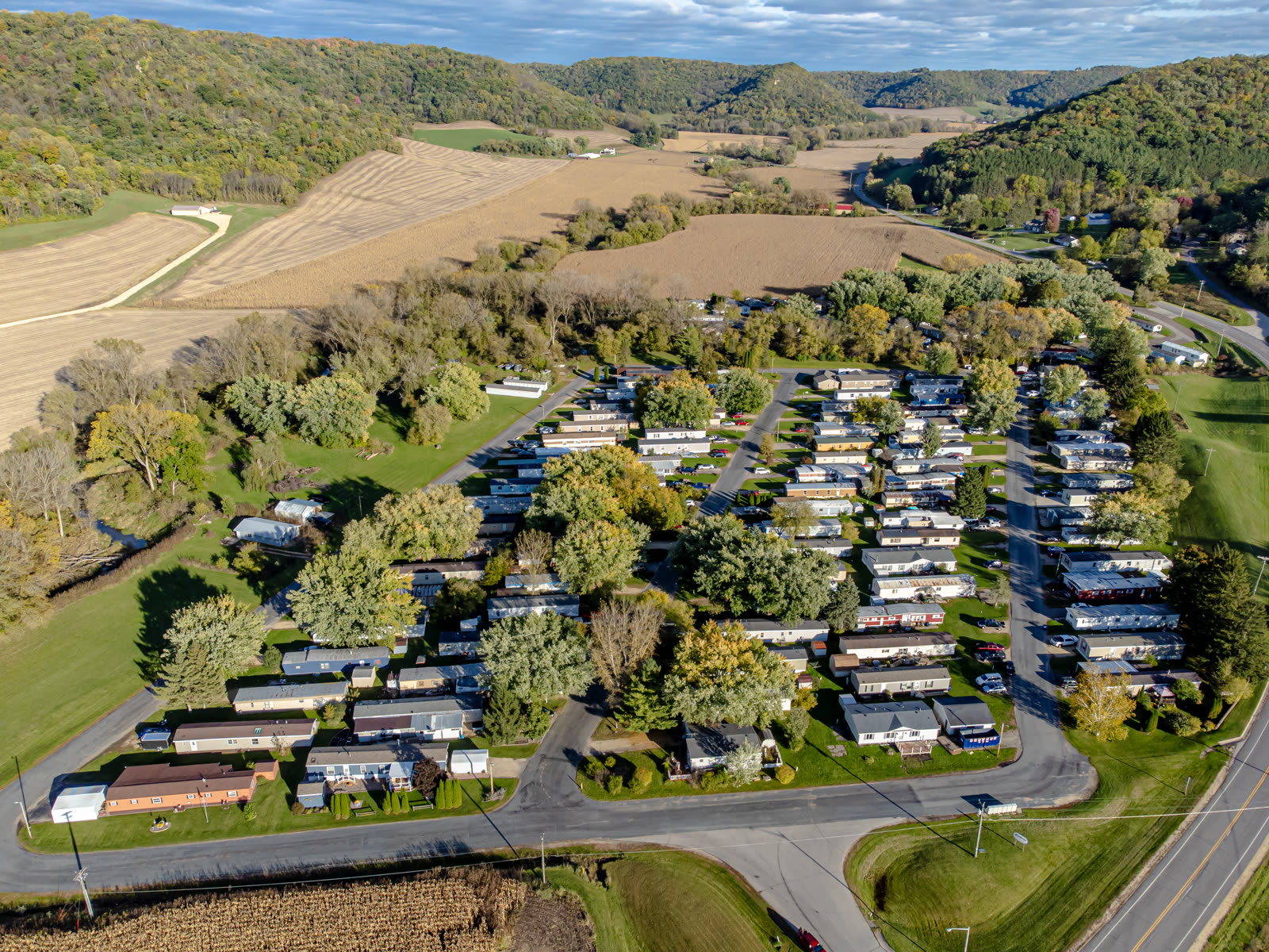 An aerial photograph of a mobile-home community bordered by farmland and tree-covered hills near La Crosse, Wisconsin.