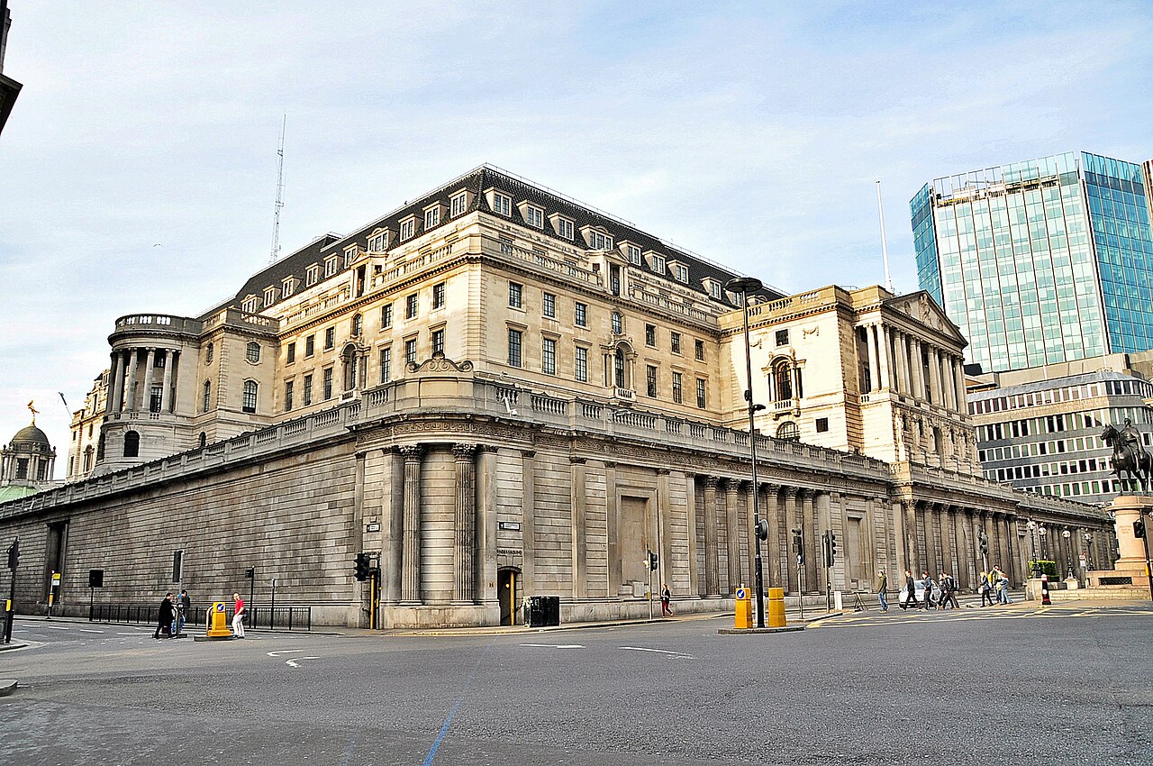 Pedestrians pass the stone facade of the Bank of England on Threadneedle Street in London.