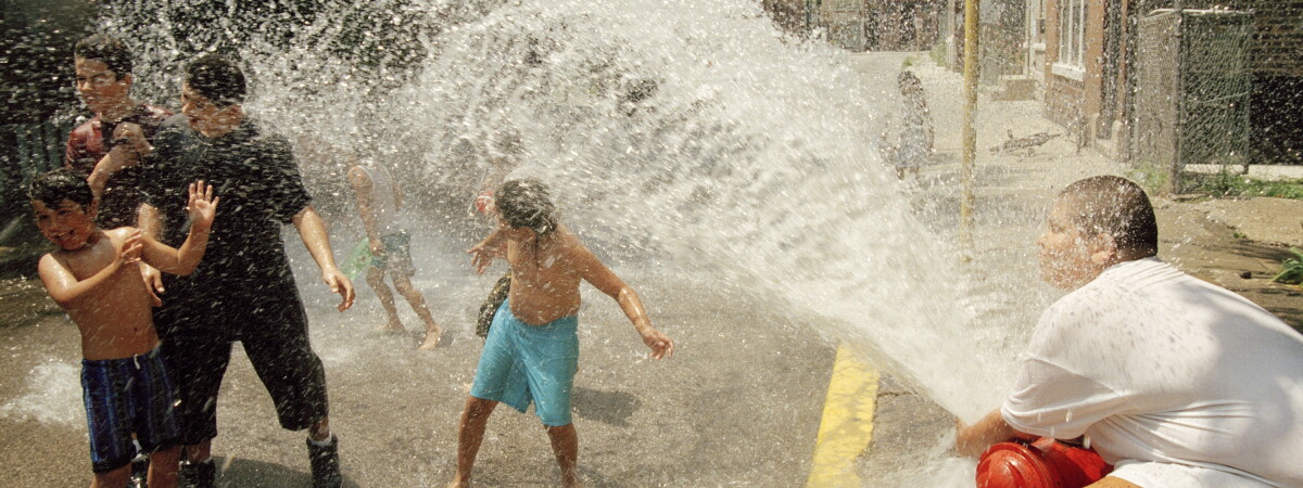 Archival photograph of Chicago children cooling off in water from a fire hydrant during the July 1995 heat wave.