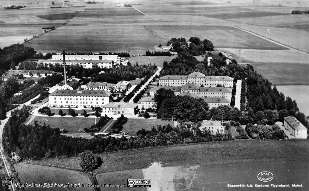 20 世纪 50 年代中期以前，隆德维佩霍尔姆医院建筑群的黑白航拍照片，四周田野环绕。