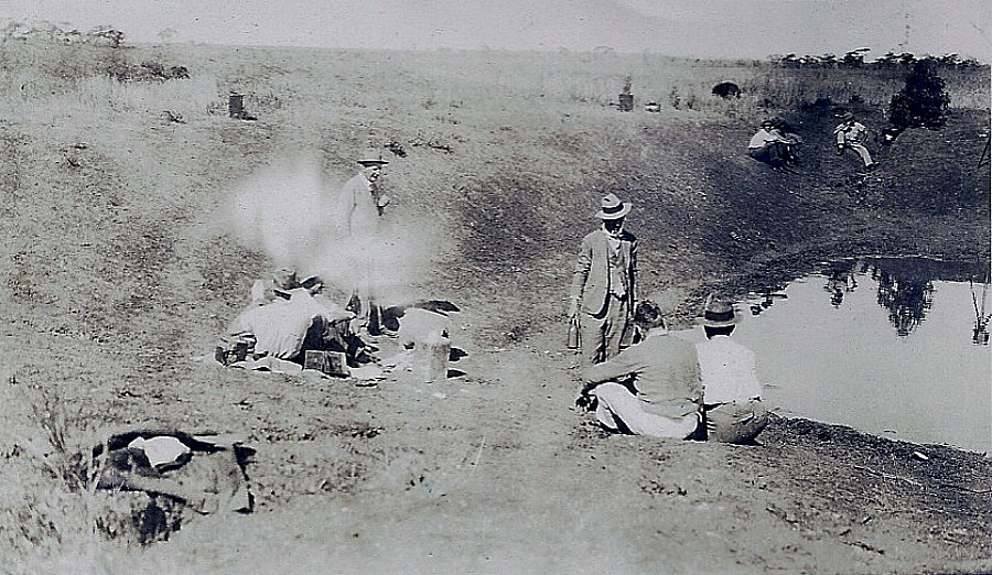 Black-and-white 1932 photograph of Australian soldiers resting beside a pool during the Emu War campaign in Western Australia.