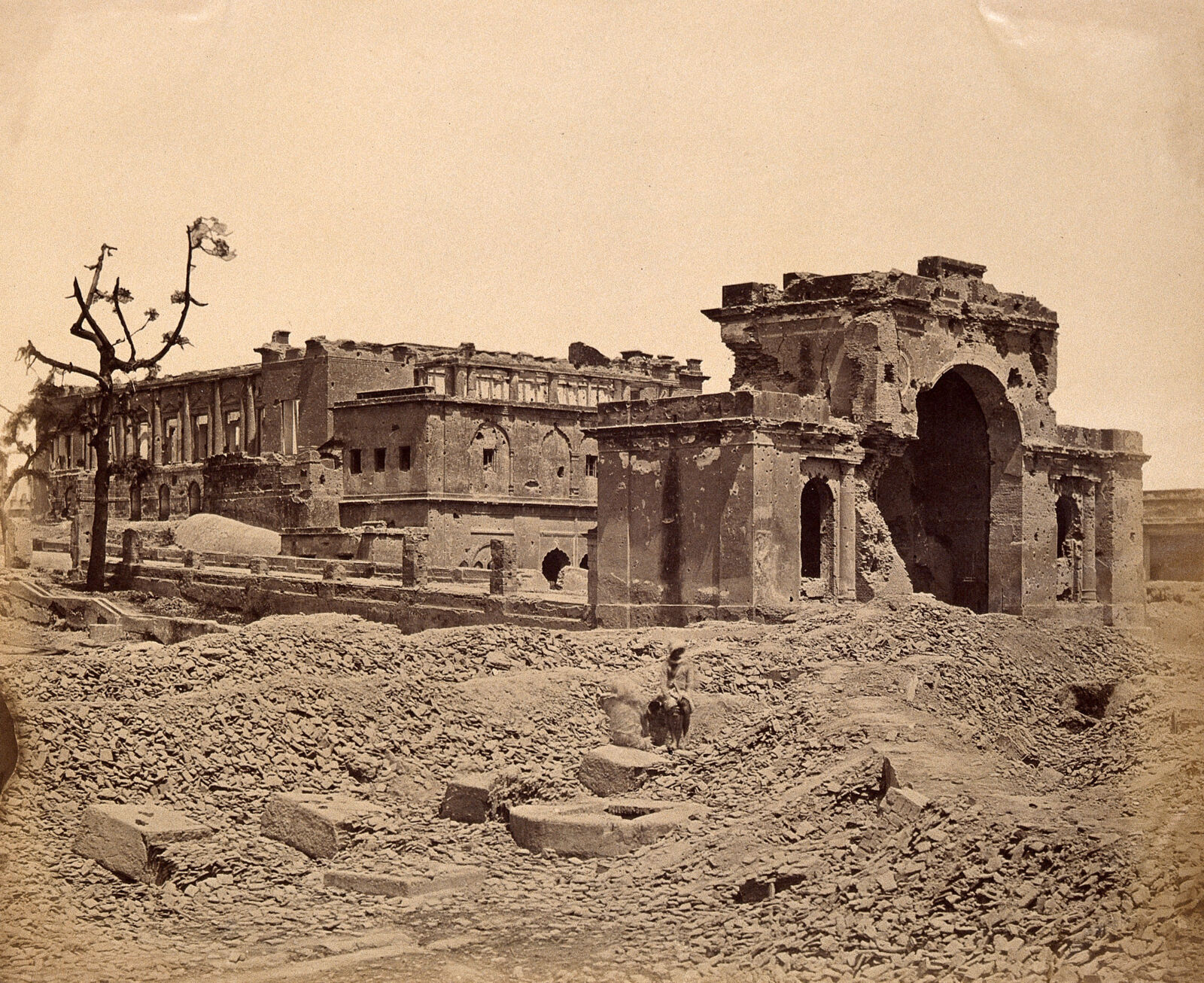 Sepia albumen photograph of the shattered gateway and banqueting room of the Lucknow Residency after the uprising of 1857.