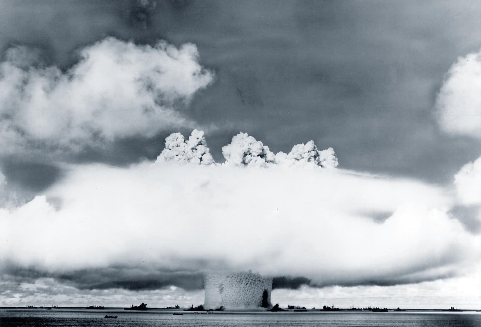 Black-and-white archival photograph of the Operation Crossroads Baker underwater atomic test rising above ships in Bikini Lagoon on July 25, 1946.