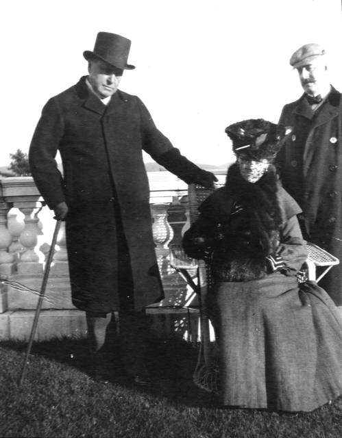 Archival black-and-white photograph of Henry James and Howard Sturgis standing beside a seated Edith Wharton on the veranda at The Mount.
