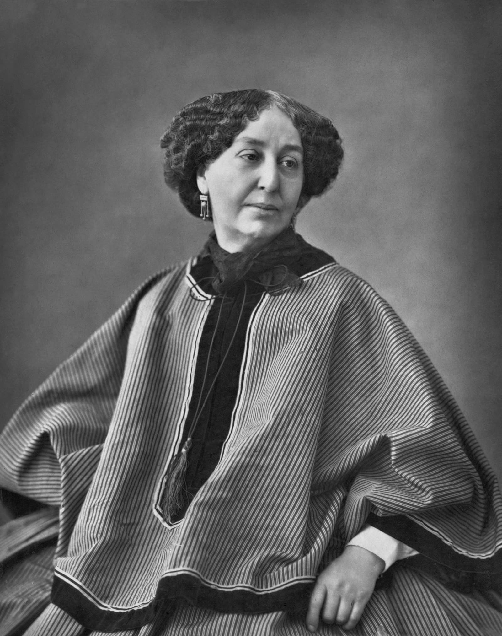 Nadar's 1864 black-and-white photographic portrait of George Sand, seated in profile against a plain background.