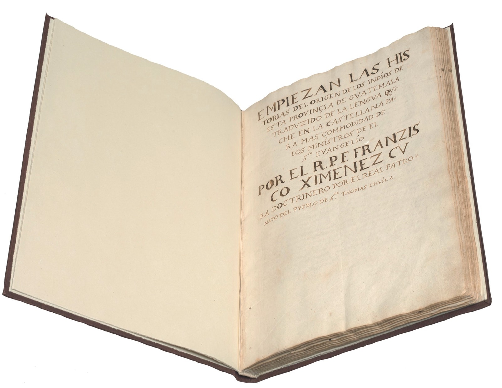 The Popol Vuh manuscript opened to its hand-lettered title page, with the worn edges and layered paper of the old volume visible.