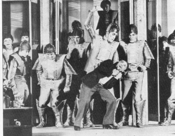 Black-and-white archival photograph of a 1928 Theatre Guild touring production of R.U.R., with performers in robot costumes standing on a geometric stage set.