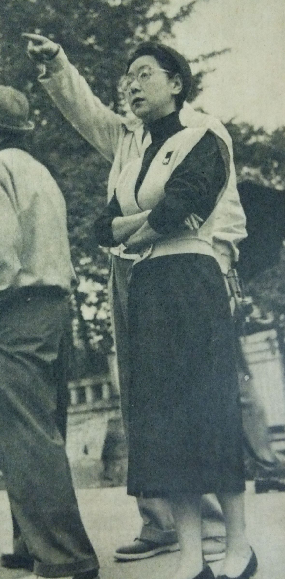 田中绢代在户外执导 1953 年电影《恋文》的黑白档案照片，她伸出一只手臂指示方向，工作人员站在近旁。