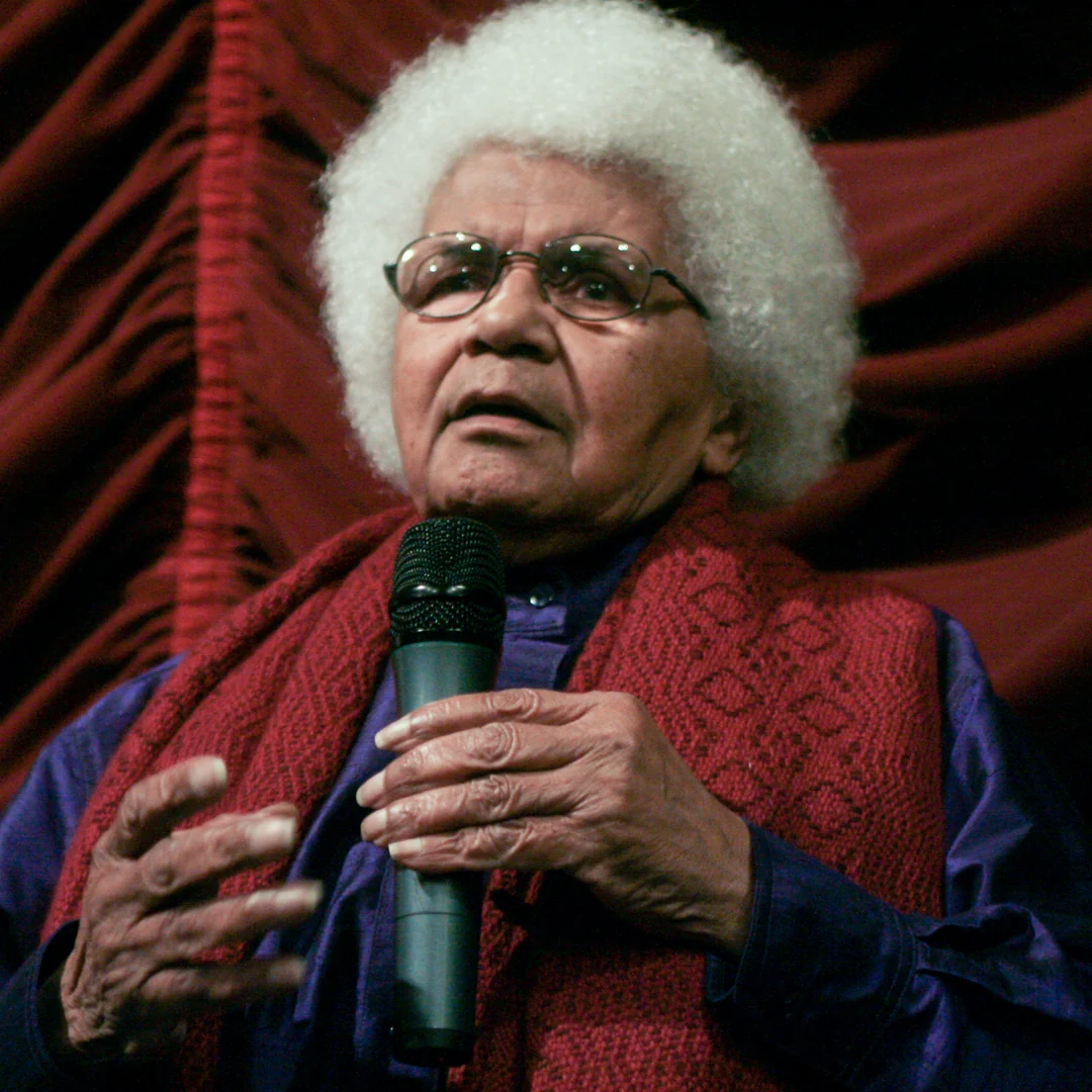 Filmmaker Sarah Maldoror speaks into a microphone during a 2009 screening discussion in France.