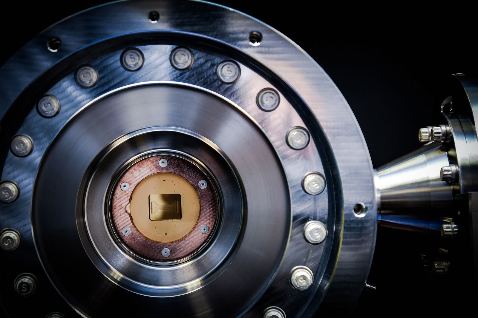 Close-up of the circular metal vacuum chamber inside Quantinuum's H2 trapped-ion quantum processor.