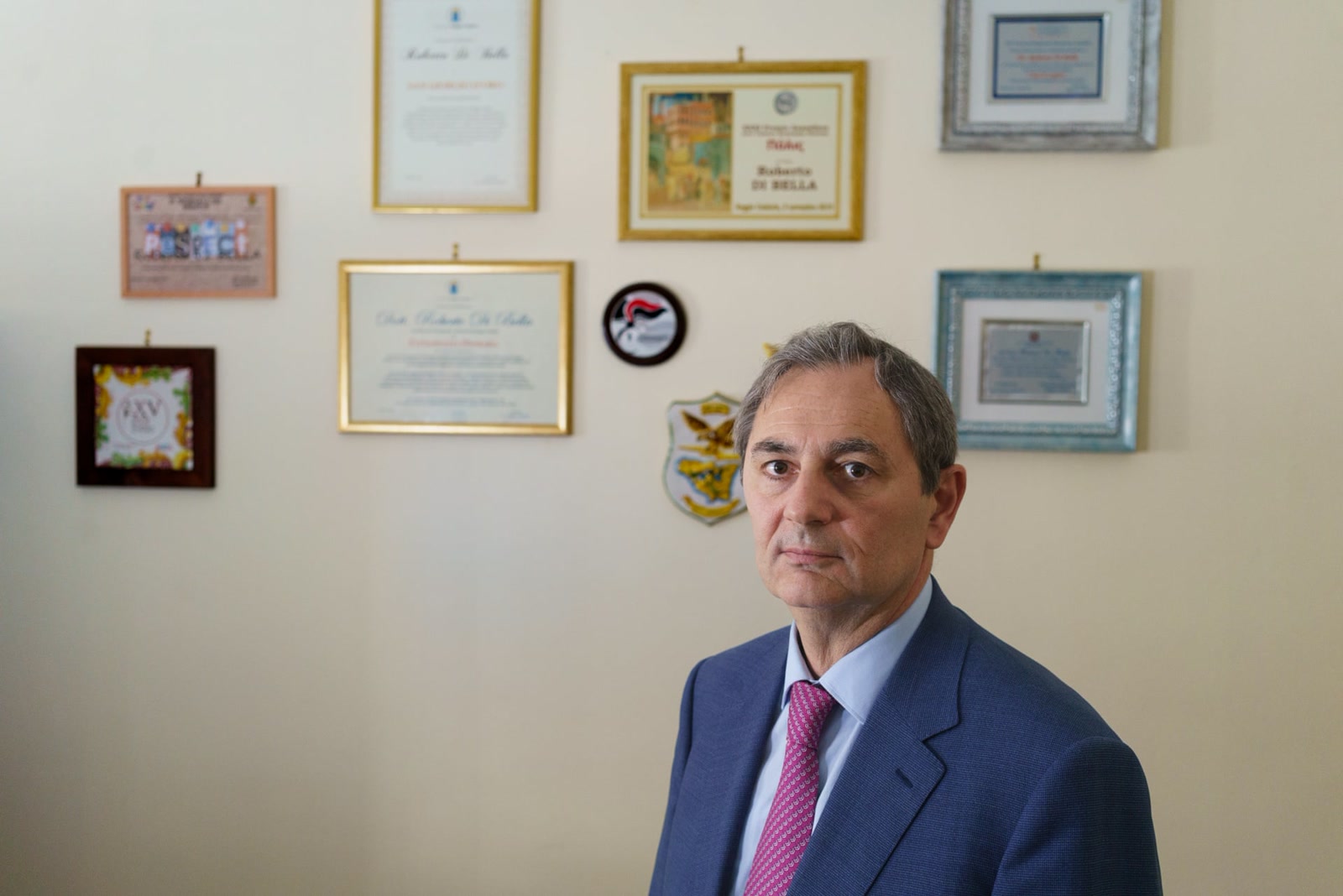 Italian juvenile judge Roberto Di Bella seated in his office beneath framed certificates.