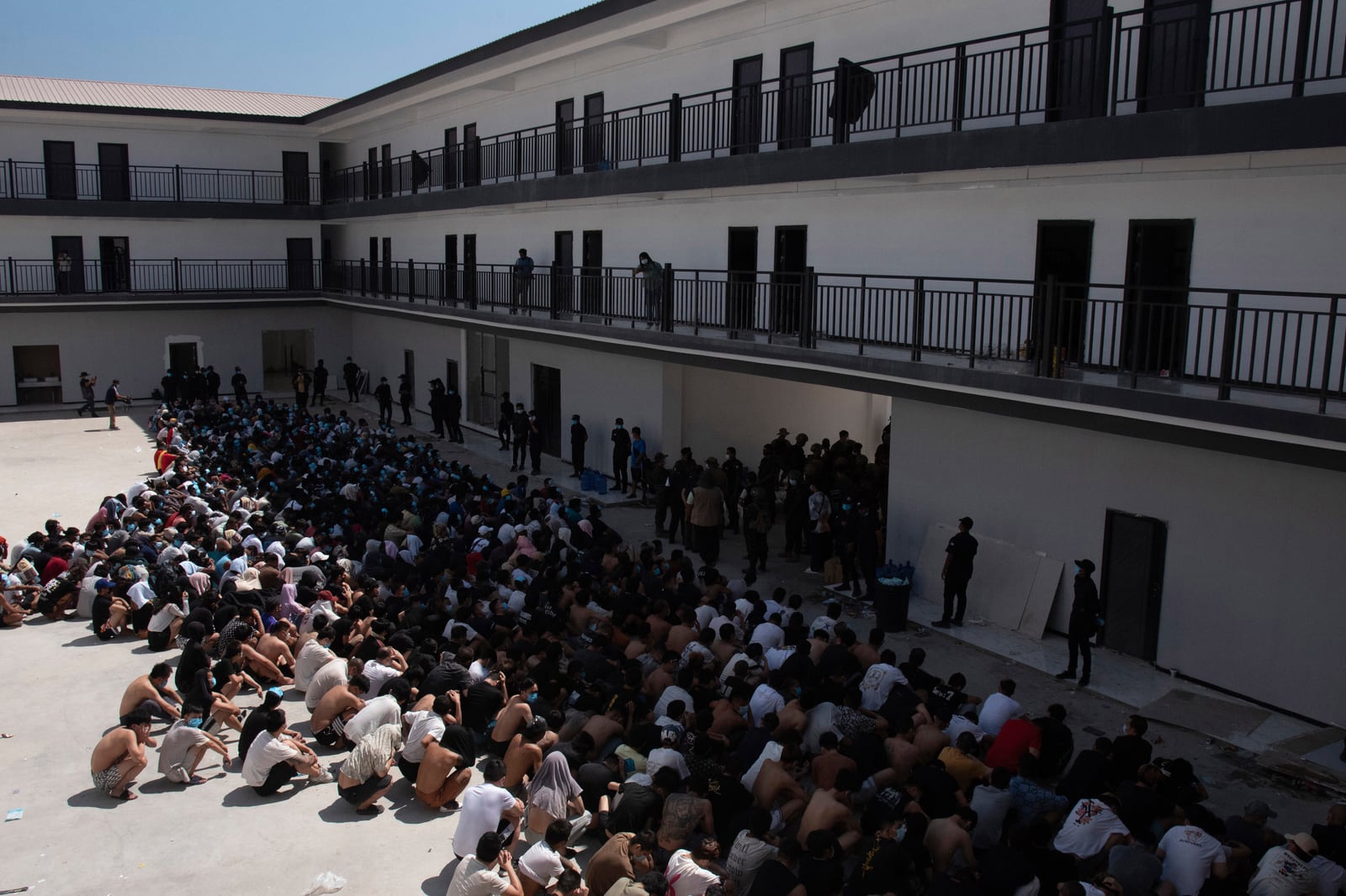 People believed to have been trafficked into scam centres sit in rows after being released from compounds in eastern Myanmar.