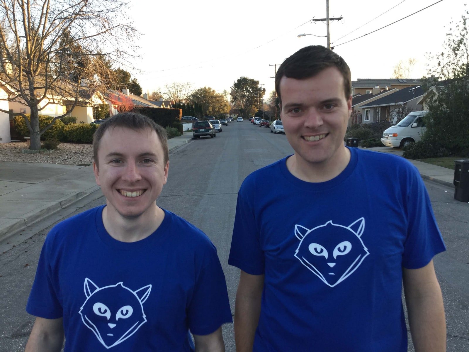 GitLab 联合创始人 Dmitriy Zaporozhets 与 Sid Sijbrandij 身穿蓝色 GitLab T 恤，并肩站在一条住宅街道上。