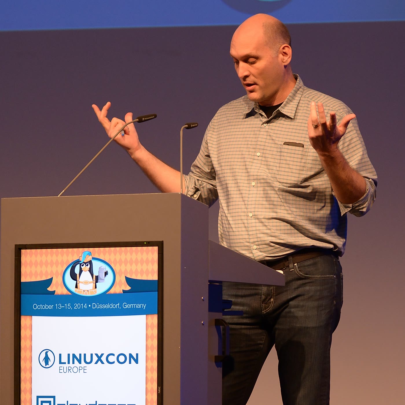 Linux 内核维护者 Greg Kroah-Hartman 在 LinuxCon Europe 讲台上发言，双手举起。
