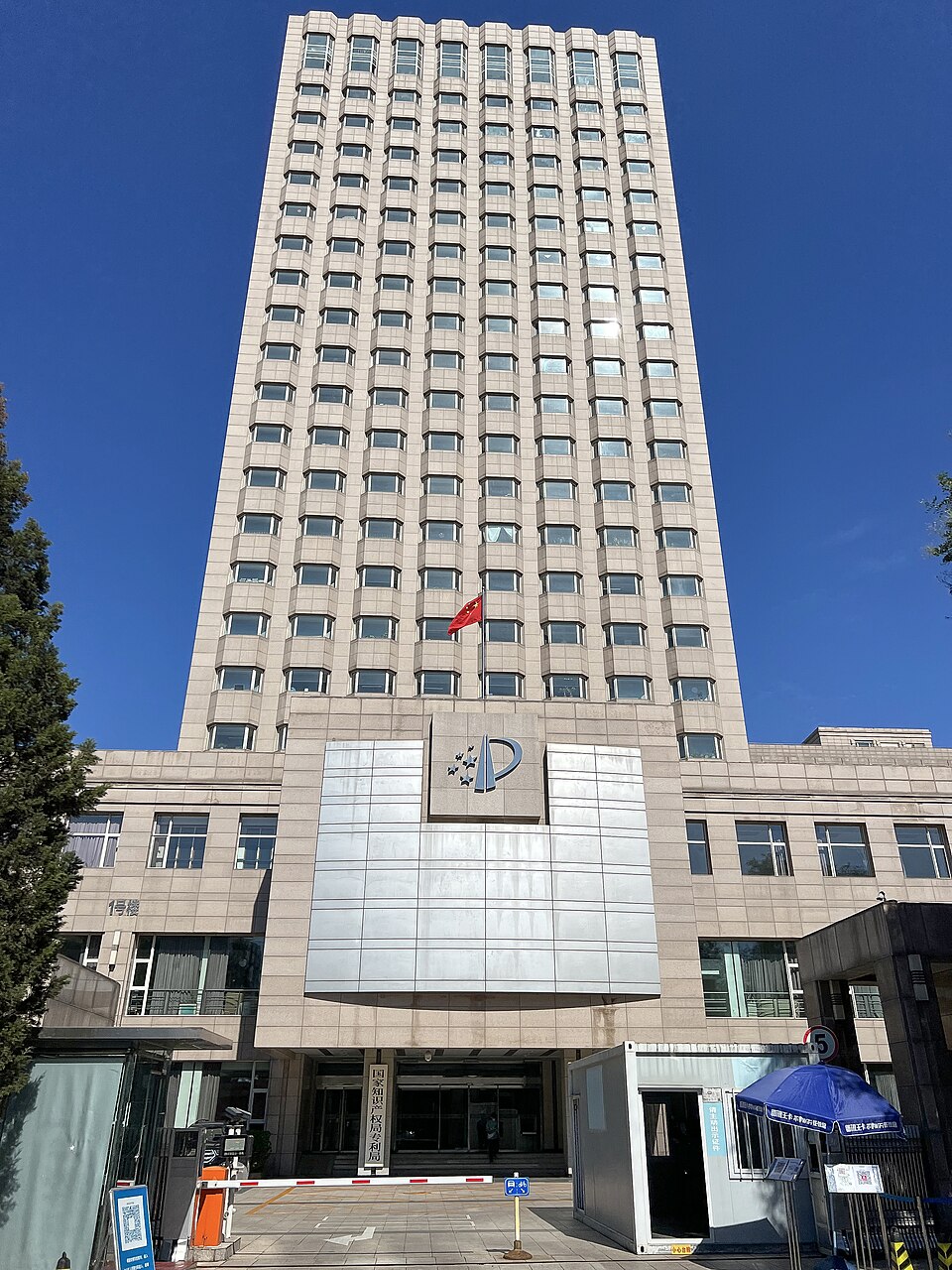 The Beijing office tower of the China National Intellectual Property Administration rises against a clear blue sky.