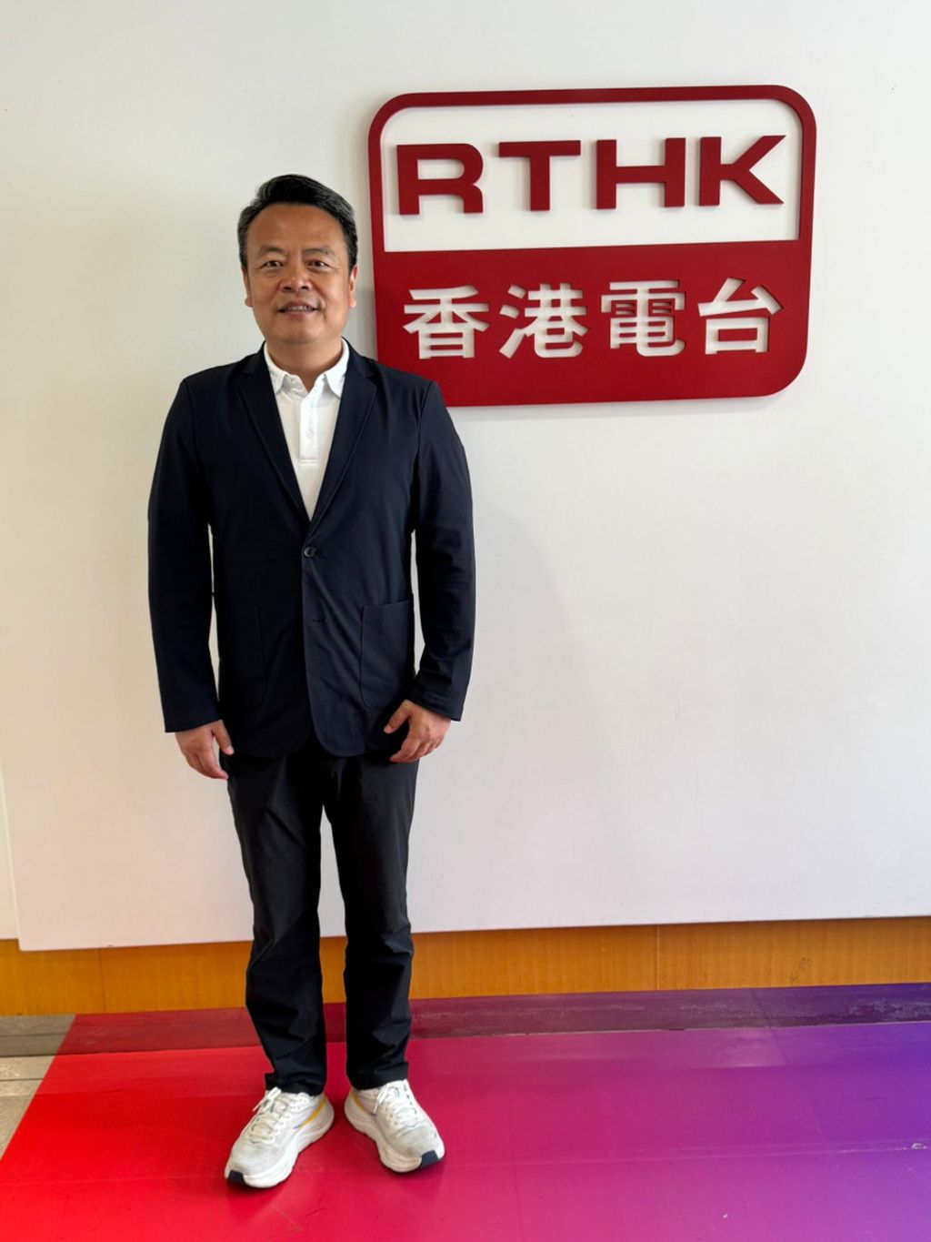 滴普科技创始人、董事长兼首席执行官赵杰辉在公司采访前站于香港电台标志旁。