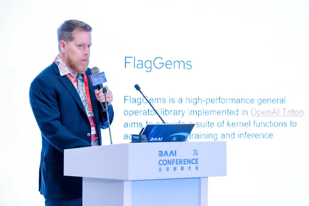 2025 年北京智源大会上，一名演讲者站在讲台前介绍 FlagGems。