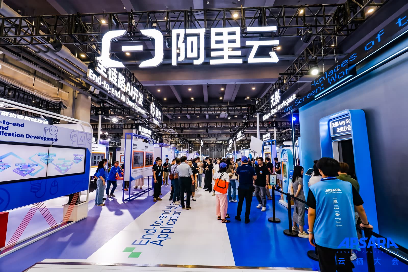 参观者走过 2024 年云栖大会的阿里云展区，上方标牌写着端到端 AI 开发与应用。