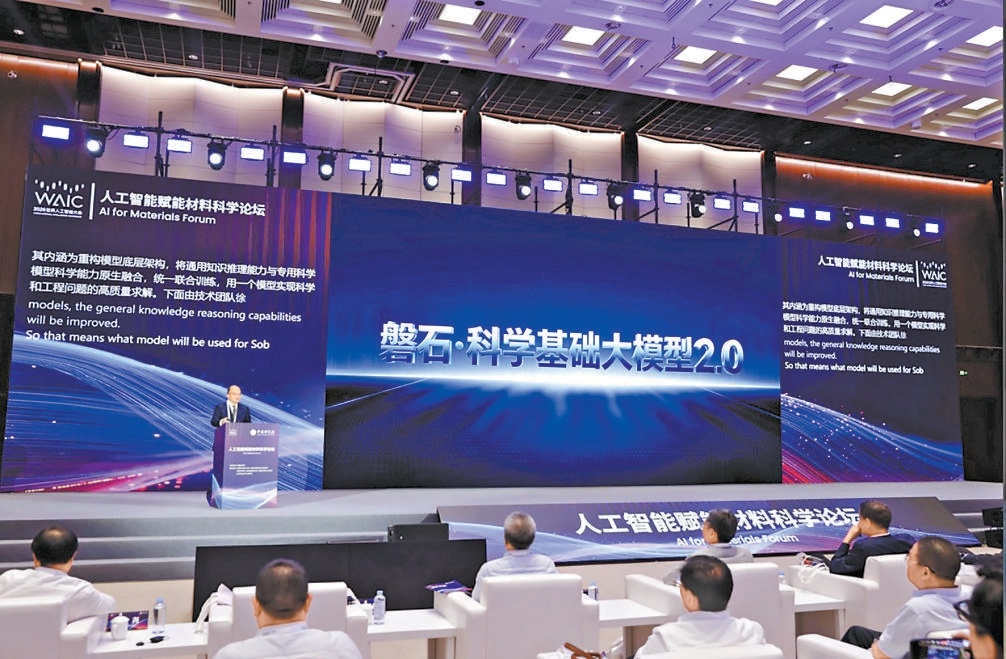 A speaker presents Panshi 2.0 on a conference stage while an audience watches beneath the AI for Materials Forum sign.