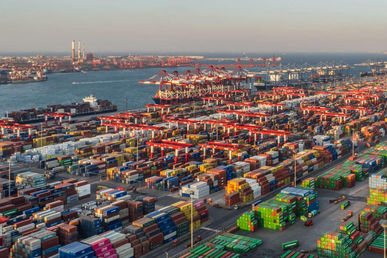 Quay cranes, automated yard equipment, and rows of containers at Qingdao Port's automated terminal.
