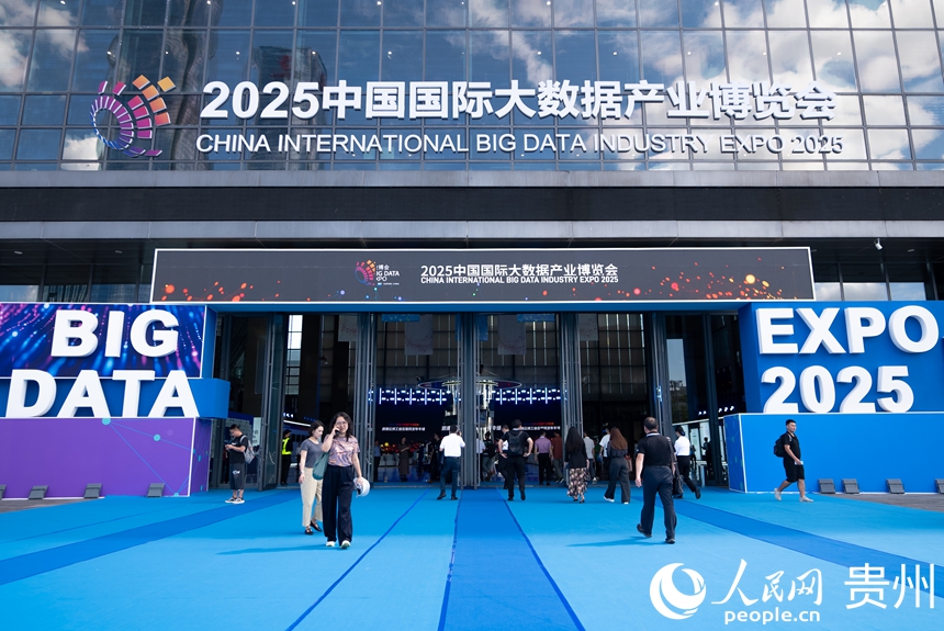 在 2025 中国国际大数据产业博览会入口处，参观者走过蓝色地毯，上方悬挂着大型中英文标牌。