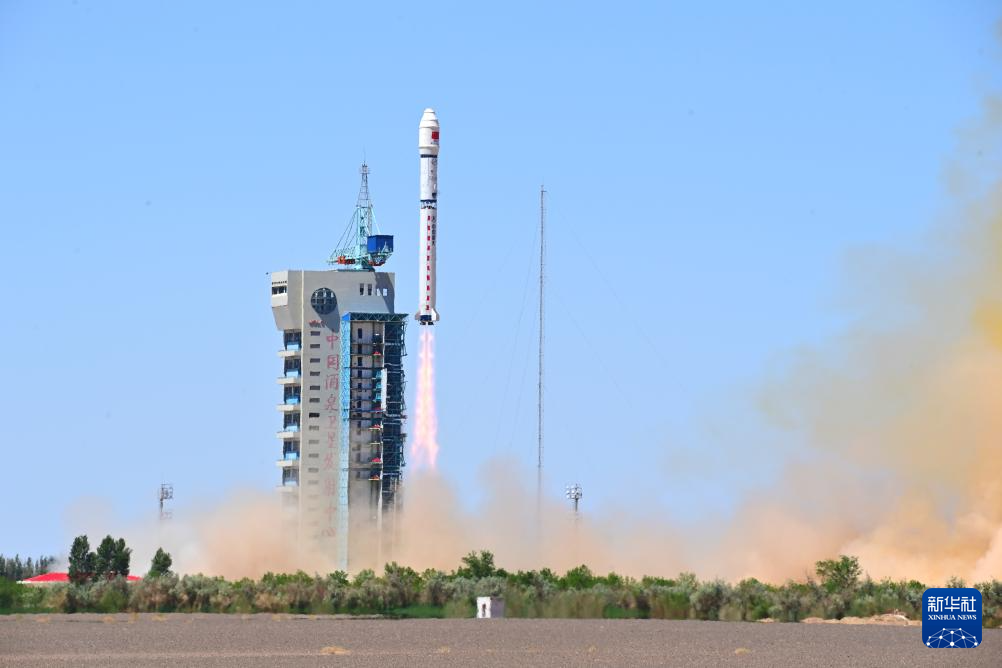 在酒泉卫星发射中心，搭载12颗太空计算卫星的长征二号丁运载火箭从发射塔旁升空。