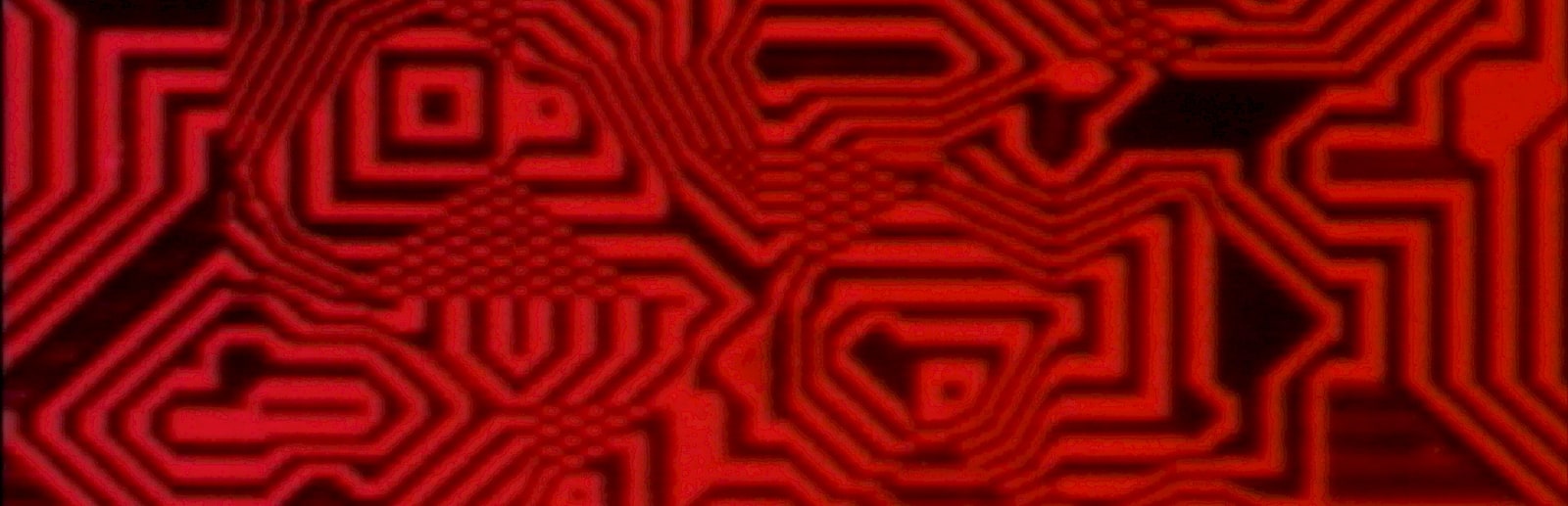 A wide film still from Lillian Schwartz's Pixillation, filled with glowing red-and-black rectangular paths, chevrons, and nested blocks.