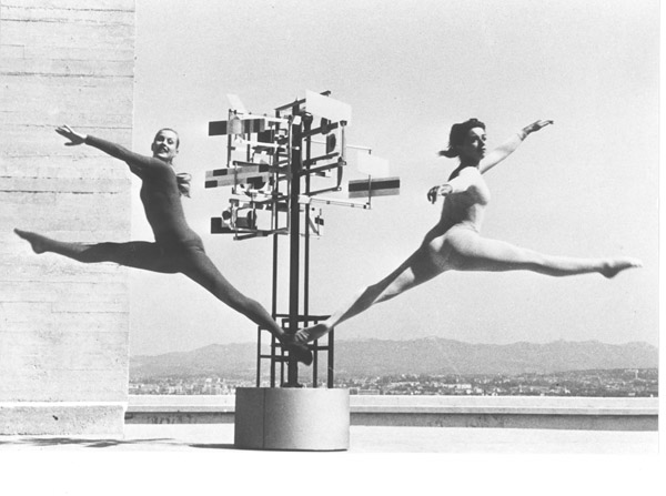 Black-and-white archival photograph of two dancers leaping on either side of Nicolas Schöffer's geometric sculpture CYSP 1 on the roof of Marseille's Cité Radieuse.