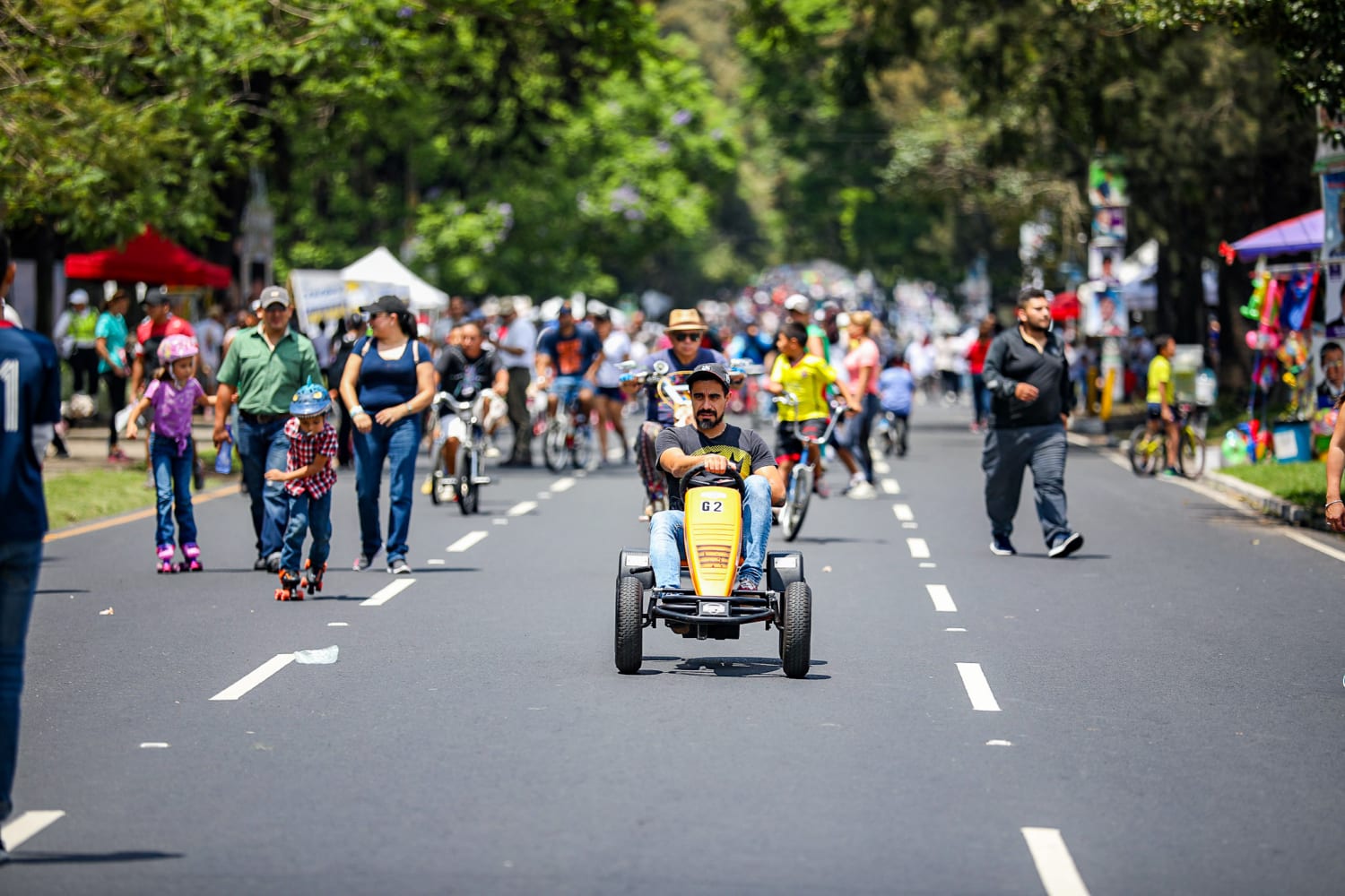Families, walkers, cyclists, skaters and a pedal-cart rider spread across the tree-lined lanes of a car-free Pasos y Pedales circuit in Guatemala City.